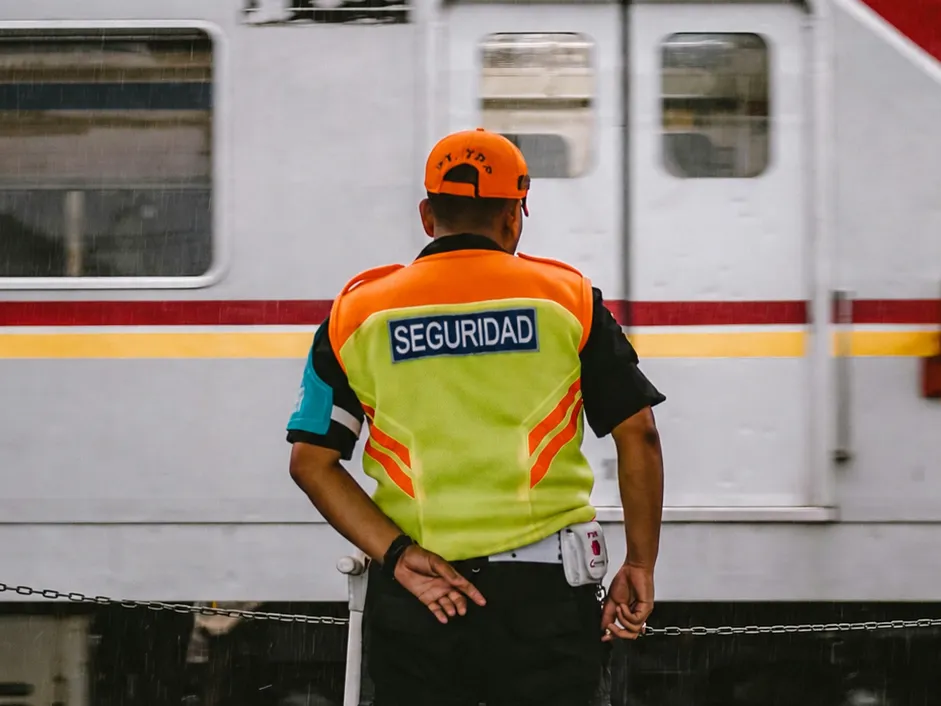 Vigilador con chaleco de seguridad en un andén